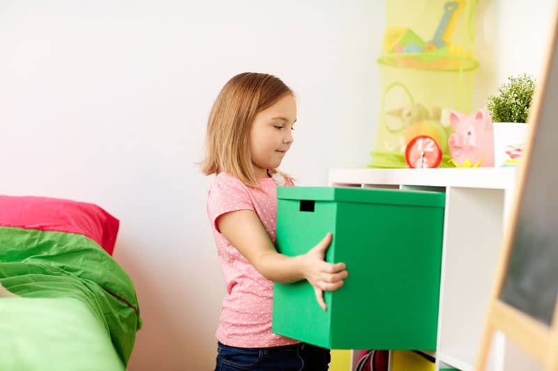 Niña guardando caja de color verde